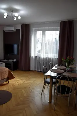 a living room with a table and chairs and a window at Travel Apartament Cracow in Kraków