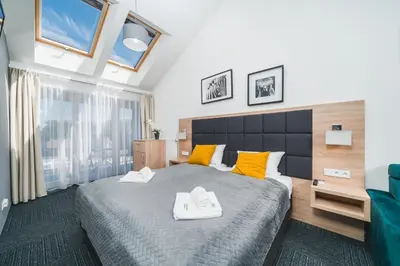a bedroom with a large bed with yellow pillows at Aron Residence - by Upstairs in Kraków
