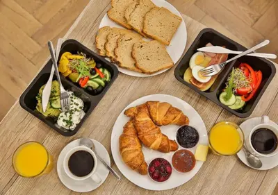 a table with three plates of breakfast foods and coffee at Aron Residence - by Upstairs in Kraków