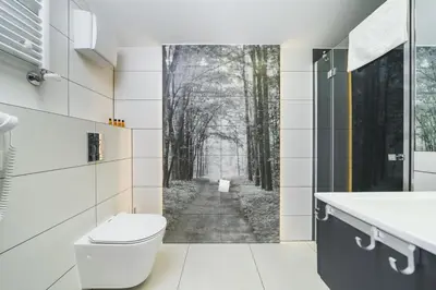 a bathroom with a toilet and a forest mural at Aron Residence - by Upstairs in Kraków
