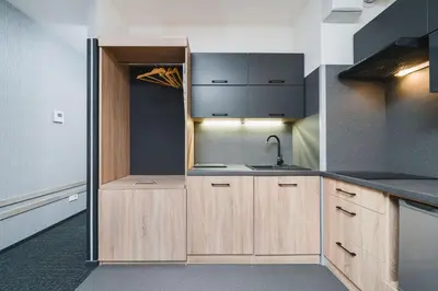 a kitchen with wooden cabinets and a sink at Aron Residence - by Upstairs in Kraków