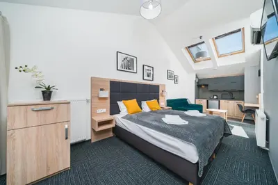 a bedroom with a bed with yellow pillows at Aron Residence - by Upstairs in Kraków
