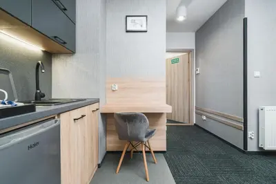 a kitchen with a counter and a chair in it at Aron Residence - by Upstairs in Kraków