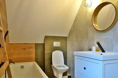 a bathroom with a toilet and a sink and a mirror at Wyspa Zdarzeń - klimatyczny dom w sercu natury! in Żmiąca