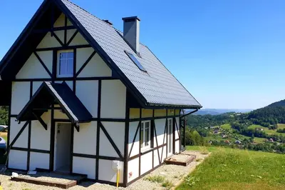 a black and white building on a hill at Wyspa Zdarzeń - klimatyczny dom w sercu natury! in Żmiąca