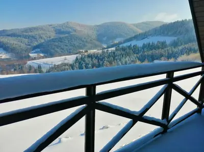a view of a snowy mountain from a balcony at Wyspa Zdarzeń - klimatyczny dom w sercu natury! in Żmiąca