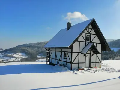 a black and white barn in the snow at Wyspa Zdarzeń - klimatyczny dom w sercu natury! in Żmiąca