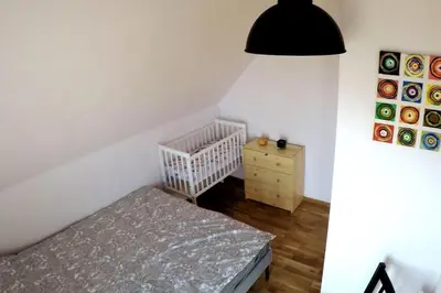 a small bedroom with a crib and a dresser at Wyspa Zdarzeń - klimatyczny dom w sercu natury! in Żmiąca
