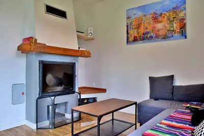 a living room with a couch and a fireplace at Wyspa Zdarzeń - klimatyczny dom w sercu natury! in Żmiąca
