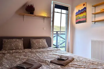 a bedroom with a bed with two towels on it at Wyspa Zdarzeń - klimatyczny dom w sercu natury! in Żmiąca