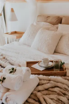a bed with a tray with towels and a coffee cup on it at The View House Rabka-Zdrój WELLNESS & SPA in Rabka