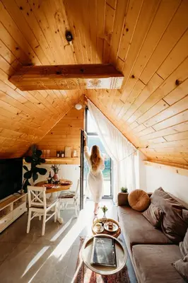 a woman standing in a living room looking out the window at The View House Rabka-Zdrój WELLNESS & SPA in Rabka
