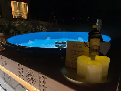 a blue tub with a bottle of alcohol and candles at The View House Rabka-Zdrój WELLNESS & SPA in Rabka