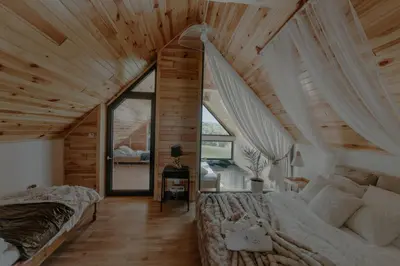 a bedroom with a bed and a large window at The View House Rabka-Zdrój WELLNESS & SPA in Rabka