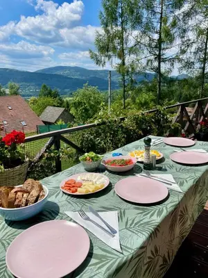 a table with plates and bowls of food on it at Klimatyczny dom z widokiem na Babią - kominek i ogrodzenie in Maków Podhalański