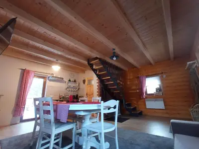 a dining room with a table and chairs and a staircase at U Krysi in Kojszówka