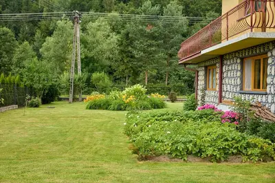 a house with a yard with flowers in front of it at Noclegi Obidowa-Pod Grapą in Obidowa