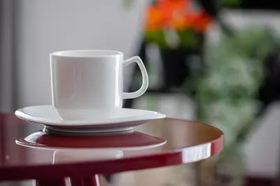 a white coffee cup sitting on top of a table at Apartment Łobzowska Cracow by Noclegi Renters in Kraków