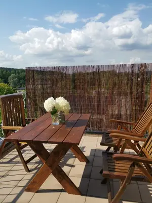 a wooden table with a vase of flowers on a patio at SOSNOWA 23 in Tenczynek