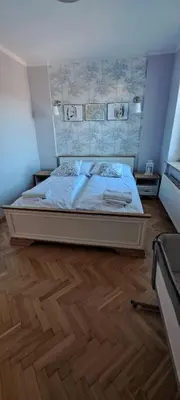 a bedroom with a large bed with a wooden floor at SOSNOWA 23 in Tenczynek