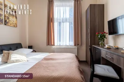 a hotel room with a bed and a television at DOMINGO Elegant Rooms KRAKÓW Old Town in Kraków