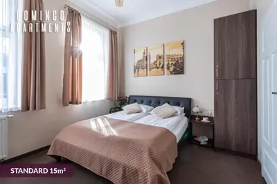 a bedroom with a bed in a room with windows at DOMINGO Elegant Rooms KRAKÓW Old Town in Kraków