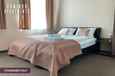 a bedroom with a bed with a blanket on it at DOMINGO Elegant Rooms KRAKÓW Old Town in Kraków