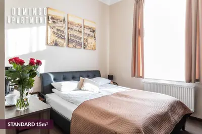 a bedroom with a bed and a vase of flowers at DOMINGO Elegant Rooms KRAKÓW Old Town in Kraków