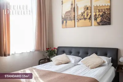a bedroom with a bed with two posters on the wall at DOMINGO Elegant Rooms KRAKÓW Old Town in Kraków