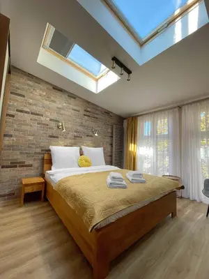 a bedroom with a large bed and a brick wall at Starowiślna 41-43 by PI Apartments in Kraków