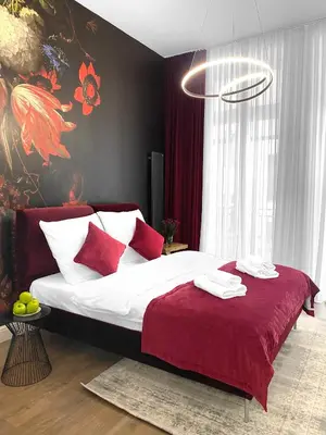 a bedroom with a large bed with red pillows at Starowiślna 41-43 by PI Apartments in Kraków