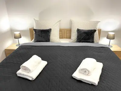 a bedroom with a bed with two white towels on it at Starowiślna 41-43 by PI Apartments in Kraków