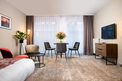 a hotel room with a bed and a table and chairs at MR67 Mayera Rapaporta in Kraków