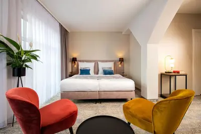 a bedroom with a bed and two chairs at MR67 Mayera Rapaporta in Kraków