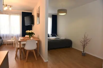a room with a table and a bedroom with a bed at Pearl Apartments-Kossak Residence Apartamenty w centrum Krakowa in Kraków