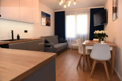 a kitchen and a living room with a table at Pearl Apartments-Kossak Residence Apartamenty w centrum Krakowa in Kraków