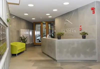 a lobby with a reception desk and a yellow chair at Pearl Apartments-Kossak Residence Apartamenty w centrum Krakowa in Kraków