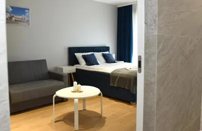 a bedroom with a bed and a couch and a table at Pearl Apartments-Kossak Residence Apartamenty w centrum Krakowa in Kraków