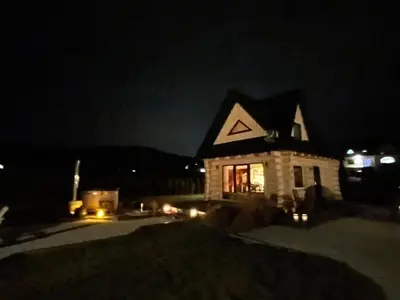 a house lit up at night with lights at Bystry domek w Beskidach przy szlaku na Babią Górę in Bystra