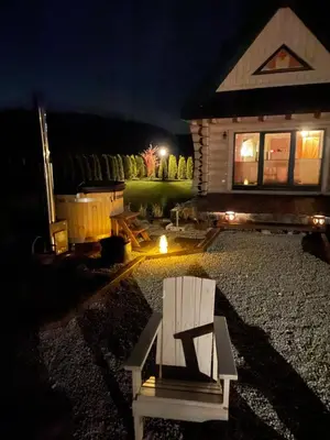a white chair in front of a house at night at Bystry domek w Beskidach przy szlaku na Babią Górę in Bystra