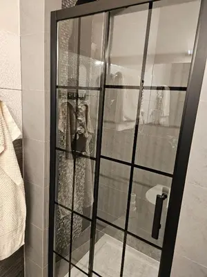 a glass shower door in a bathroom at Sara -Mikołajska - Rynek - Netflix Hydromassage in Kraków