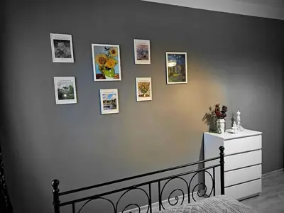 a bedroom with a wall with pictures on it at Sara -Mikołajska - Rynek - Netflix Hydromassage in Kraków