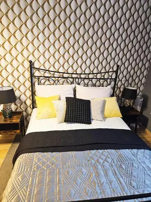 a bedroom with a bed with a large wooden wall at Sara -Mikołajska - Rynek - Netflix Hydromassage in Kraków