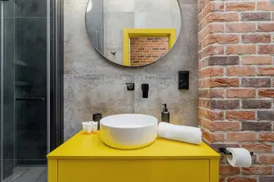 a bathroom with a sink on a yellow vanity at Old Town Studio Good Vibes by Noclegi Renters in Kraków