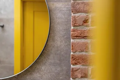 a round mirror on the side of a brick wall at Old Town Studio Good Vibes by Noclegi Renters in Kraków