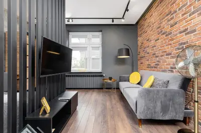 a living room with a couch and a brick wall at Old Town Studio Good Vibes by Noclegi Renters in Kraków