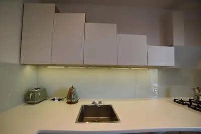 a kitchen counter with a sink and white cabinets at Designer Apartment 110m2 with King Size Beds & Equipped Kitchen in Kraków