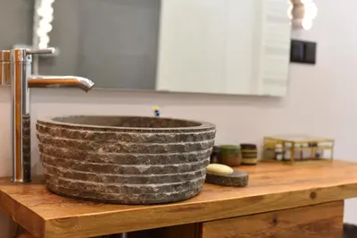 a stone sink on a wooden counter in a kitchen at Designer Apartment 110m2 with King Size Beds & Equipped Kitchen in Kraków
