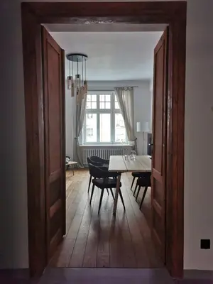 an open door into a dining room with a table and chairs at Designer Apartment 110m2 with King Size Beds & Equipped Kitchen in Kraków