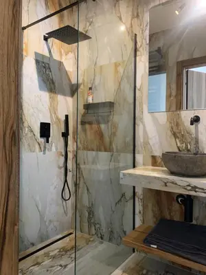 a bathroom with a shower with a stone wall at Garden Apartment Self Check-in - Bezklucz kropka info in Kraków